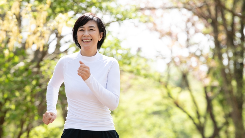 屋外でスロージョギングをする50代女性