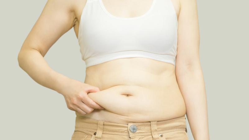 お腹の肉をつかむ中年女性