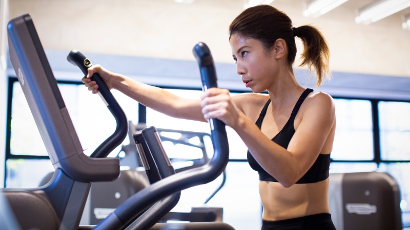 クロストレーナーで汗をかく女性